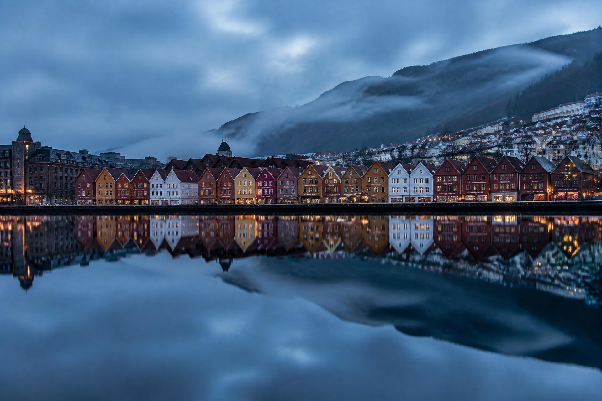 Bryggen i Bergen speiler seg i havnen i blåtimen